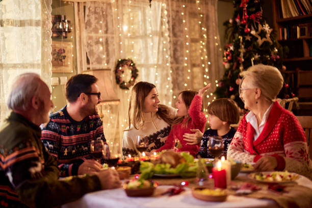 食卓でクリスマスの食事を楽しみながら、コミュニケーションをとる家族